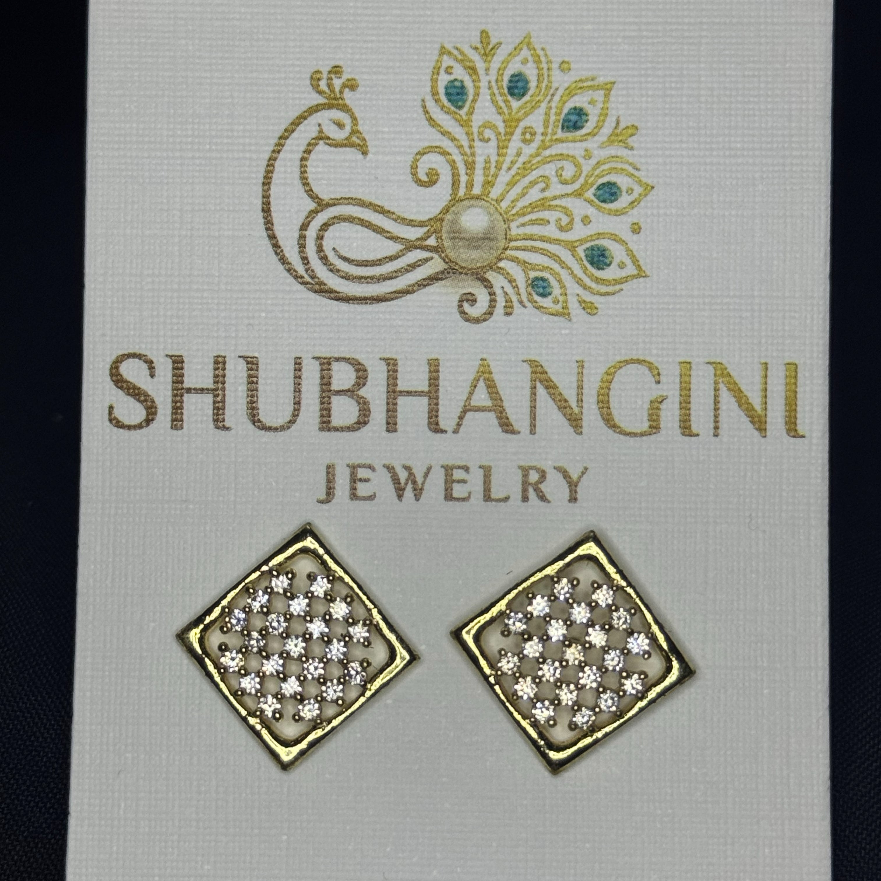 Gold and crystal earrings on a Shubhangini Jewelry card.