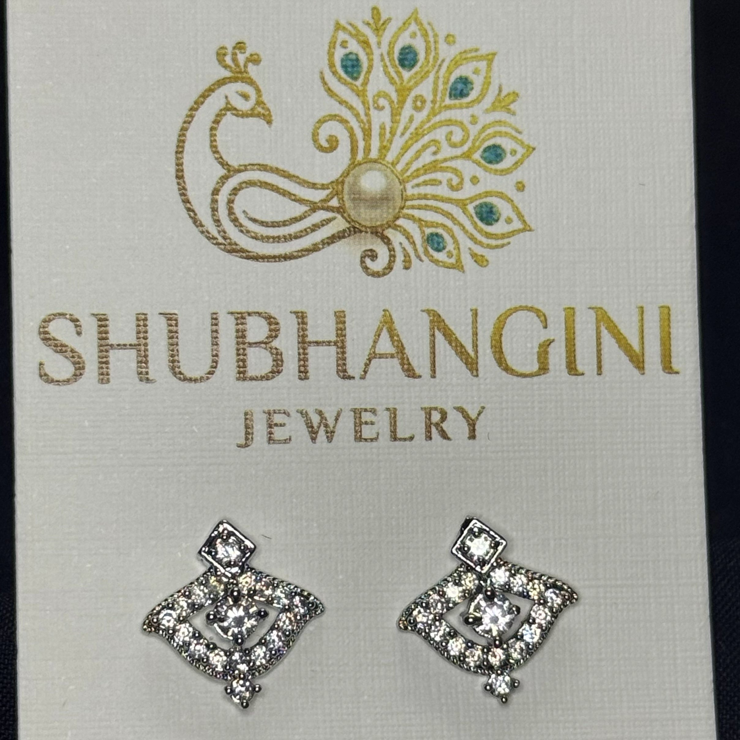 Pair of diamond-shaped earrings on a Shubhangini Jewelry card.