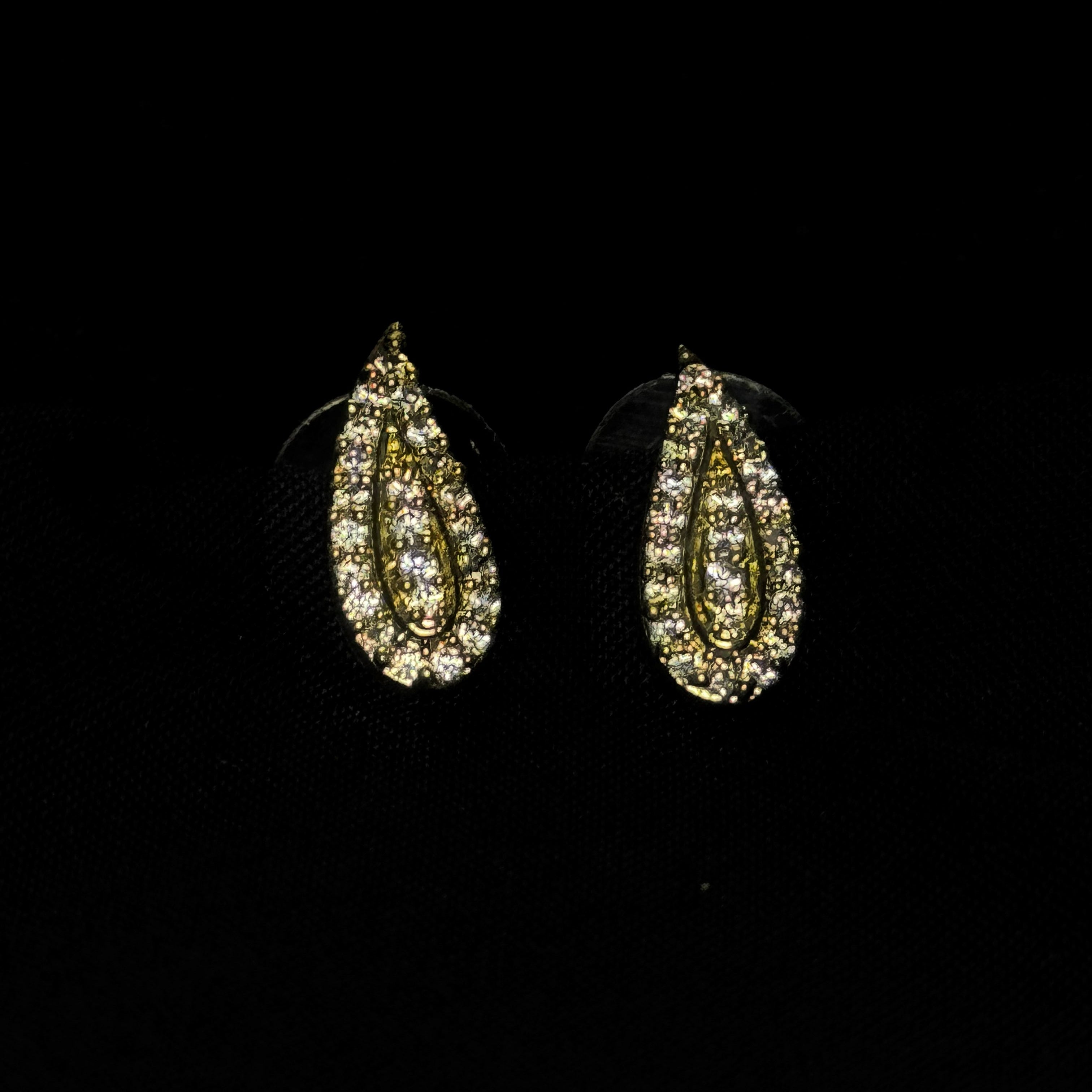 Teardrop-shaped earrings with gemstones on a black background