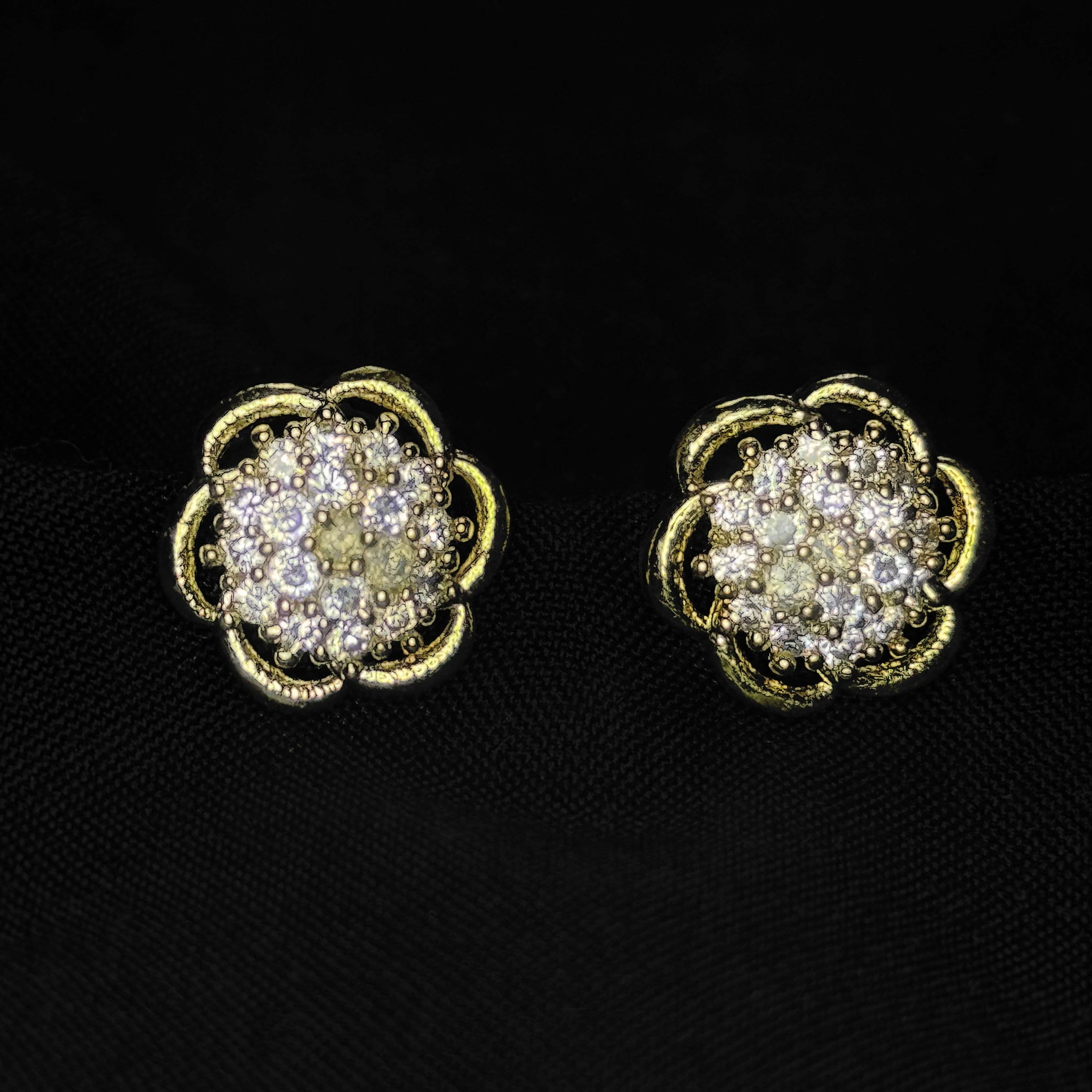 Pair of gold and diamond earrings on a black background