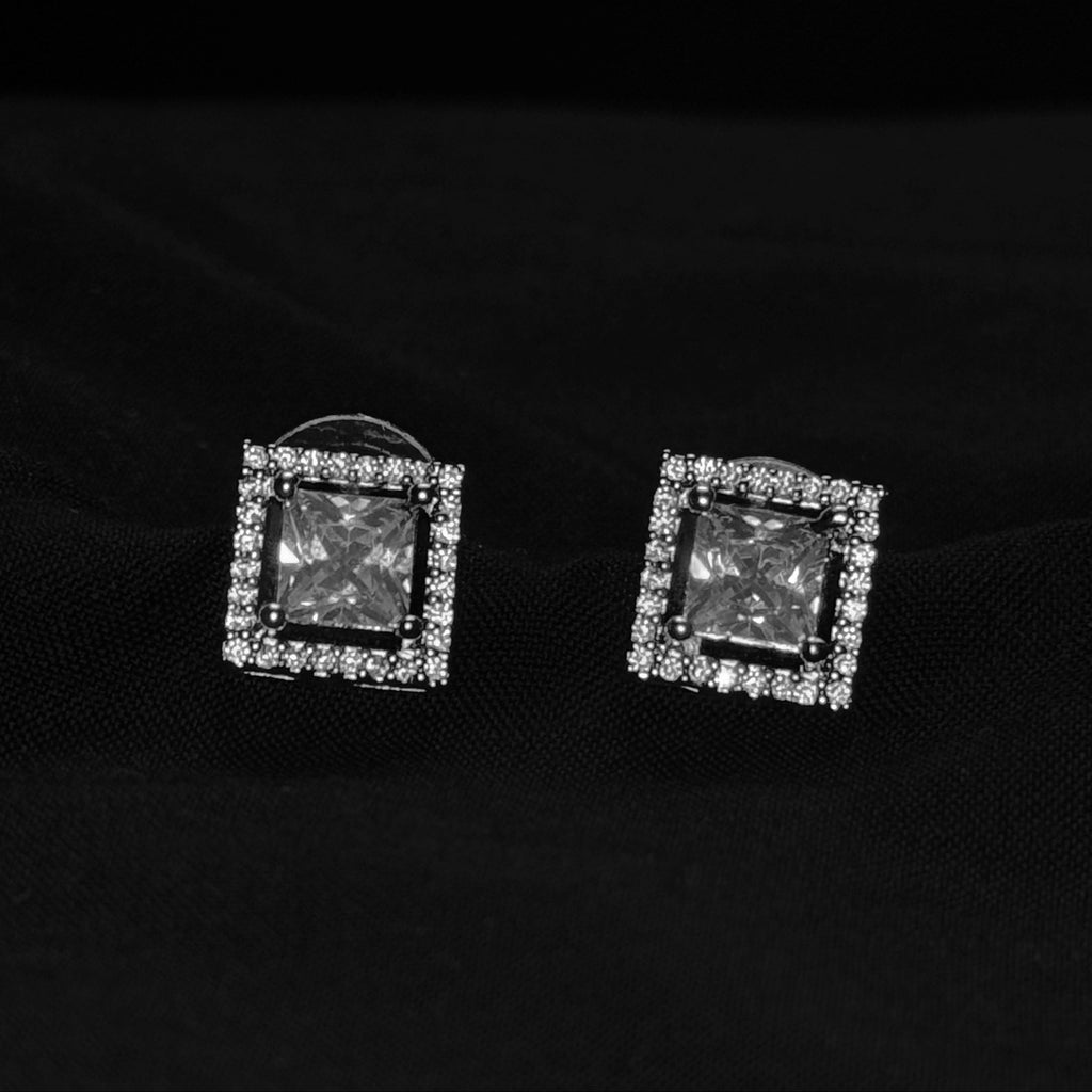 Square-shaped earrings with gemstones on a black background