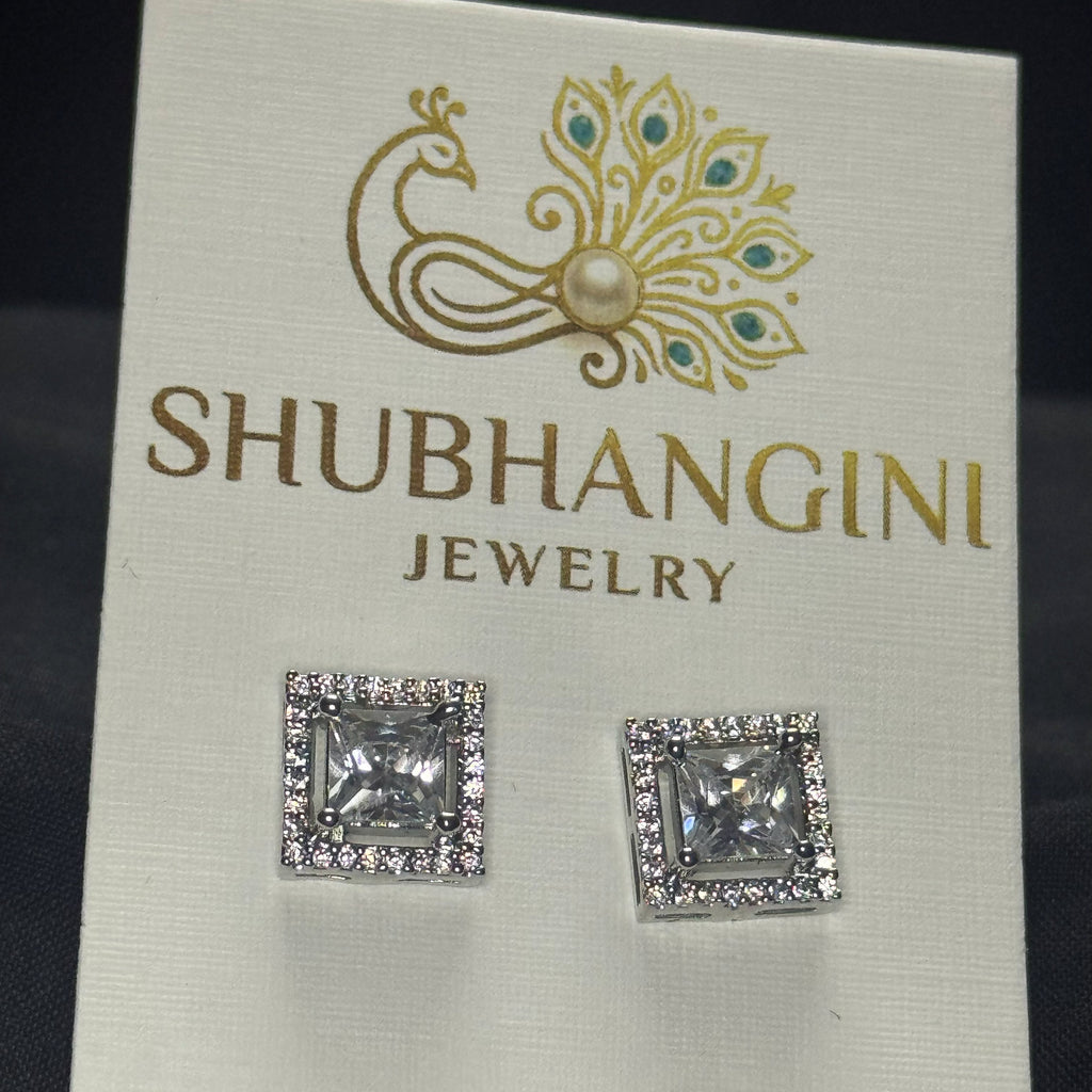 Square crystal earrings on a Shubhangini Jewelry card against a dark background