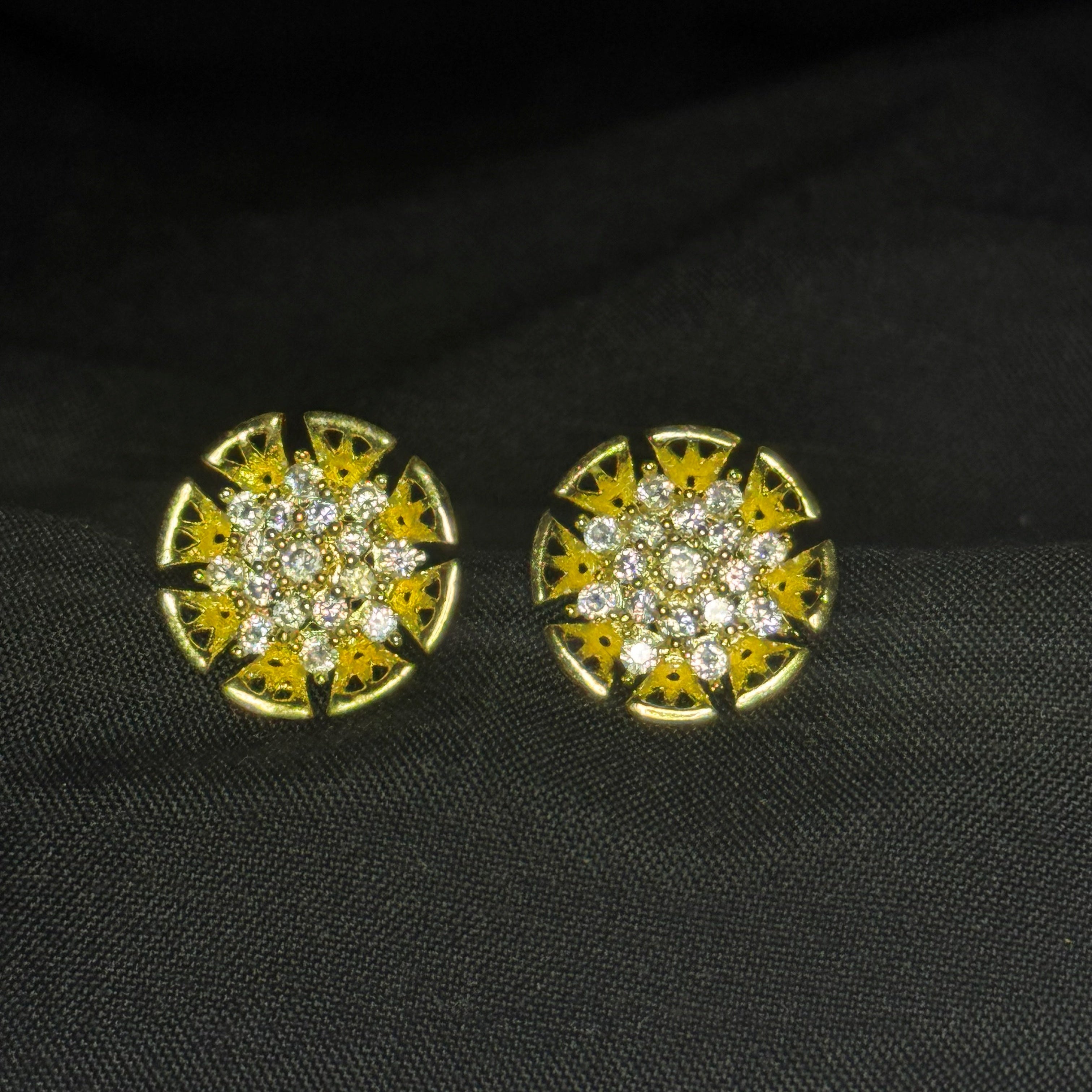 Gold and diamond earrings on a black fabric background