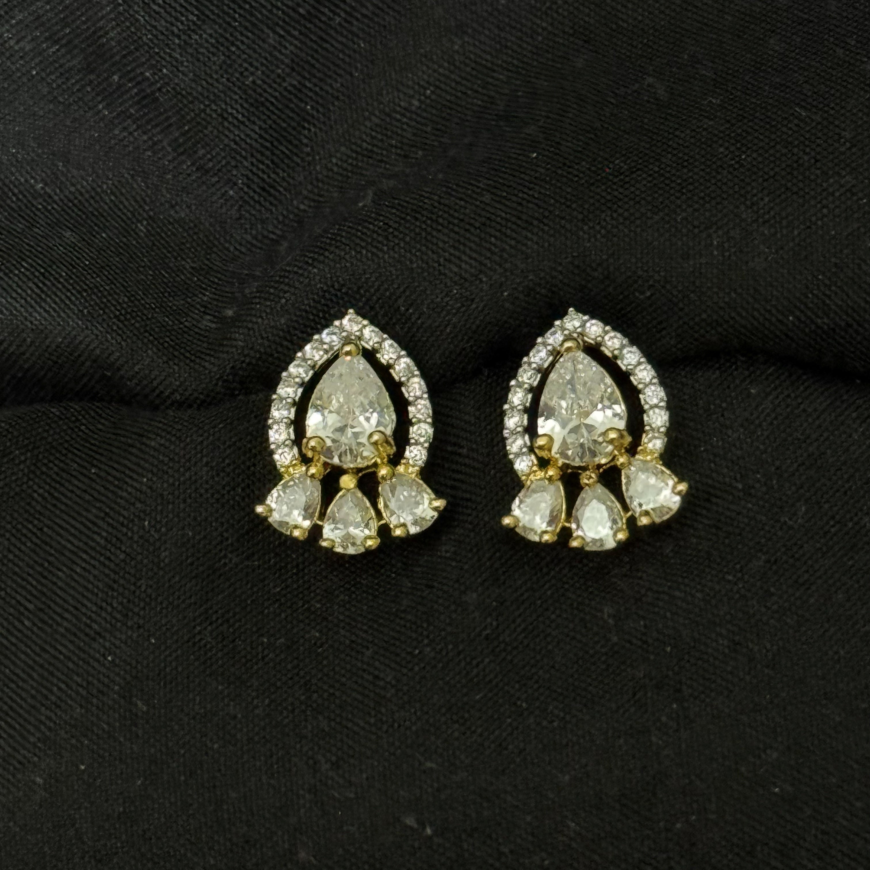 Pair of gold and diamond earrings on a black background