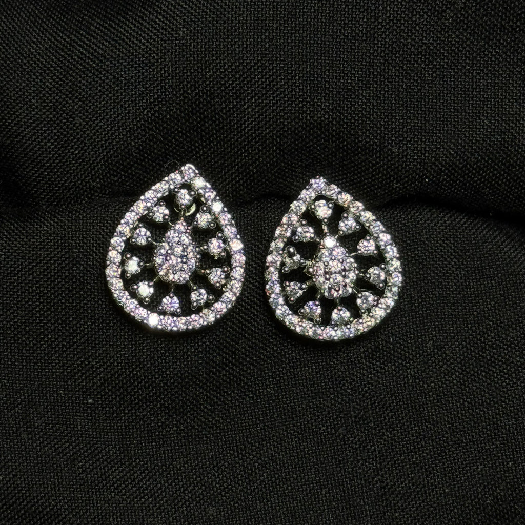 Teardrop-shaped silver earrings with gemstones on a black background