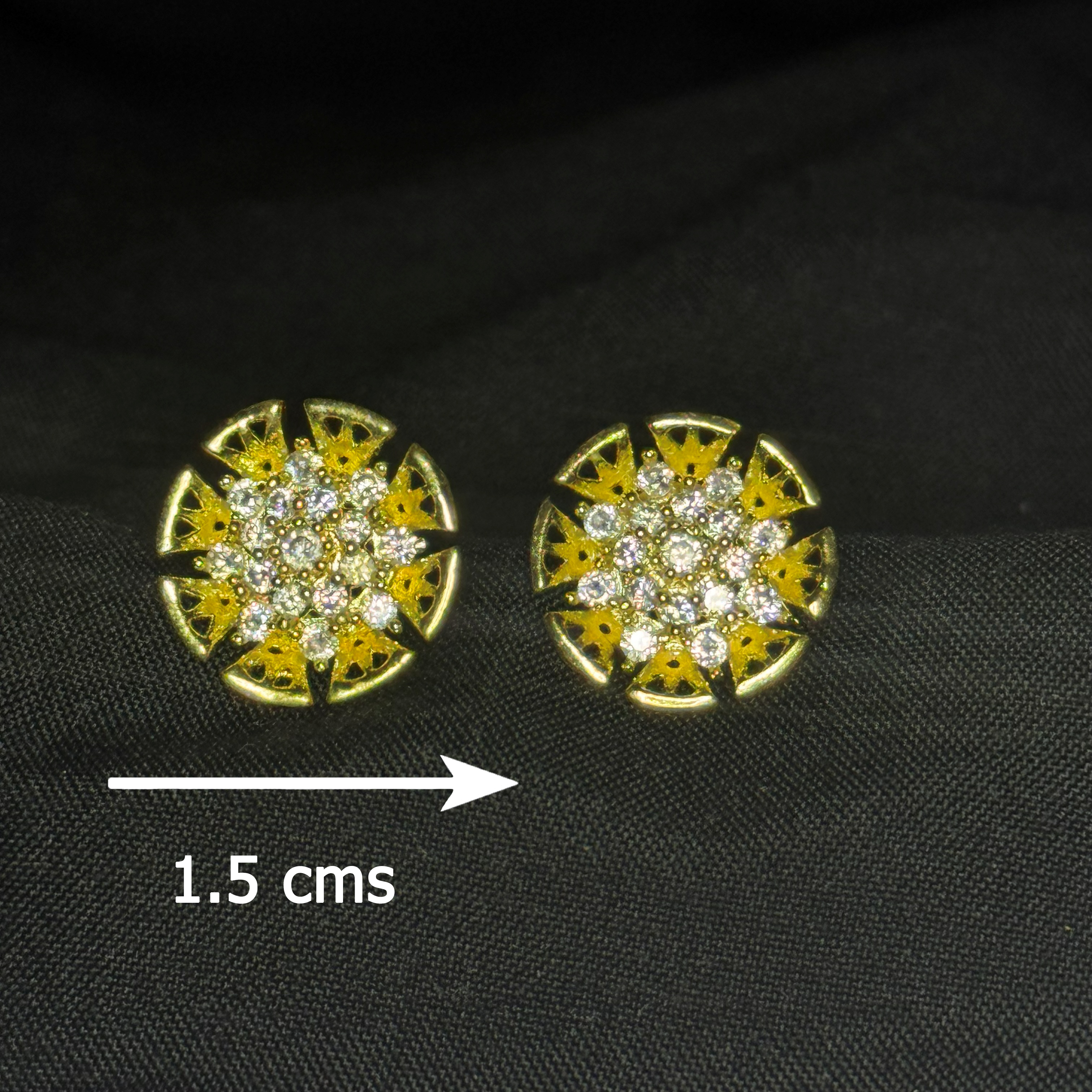 Gold and diamond earrings on a black background with measurement label.
