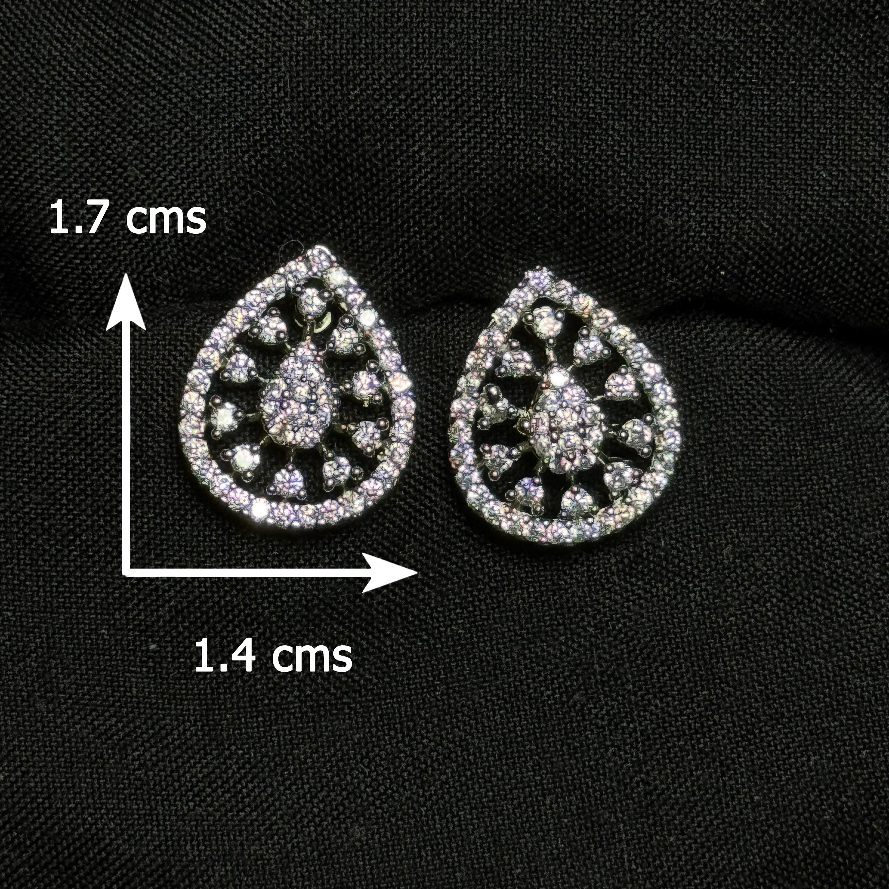 Teardrop-shaped silver earrings with gemstones on a black background, showing measurements.
